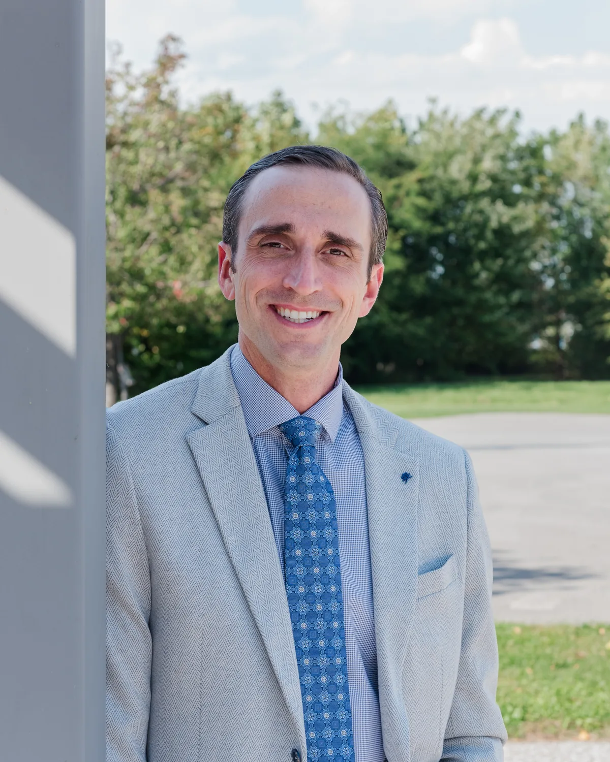 Tim Ternosky smiling, leaning against a post outdoors
