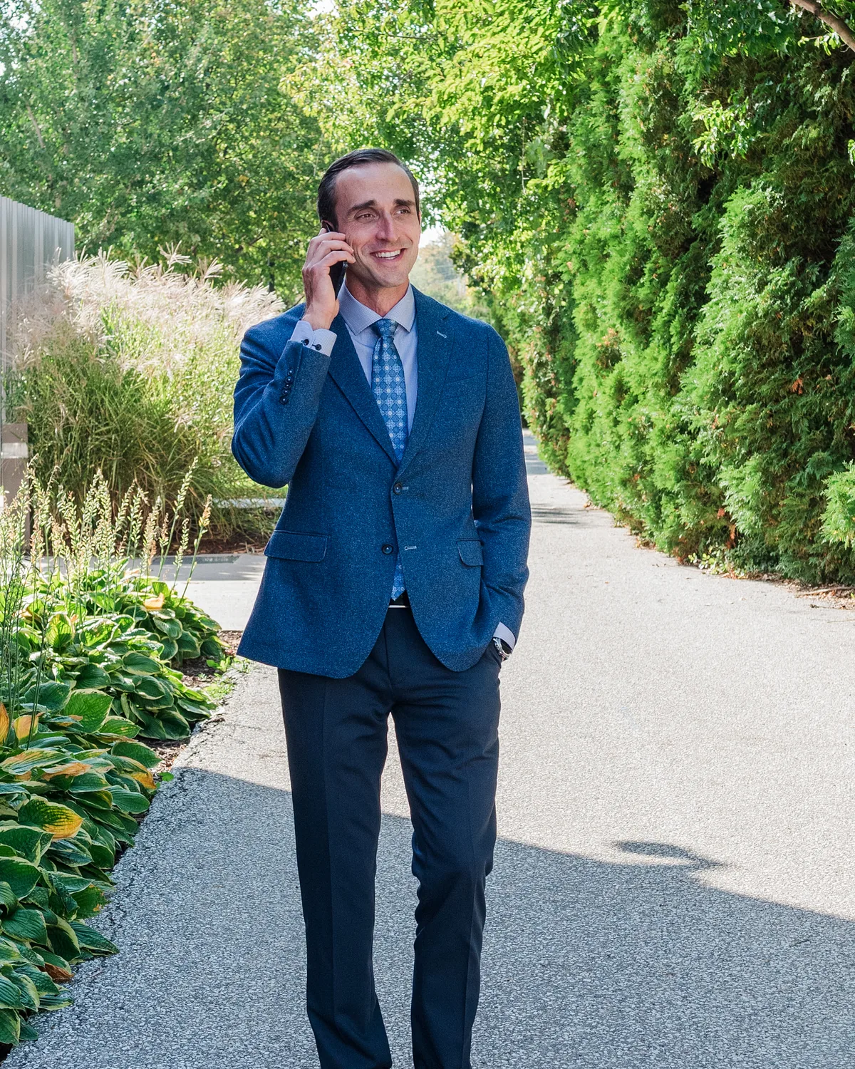 Tim Ternosky on a phone call, walking along a garden path